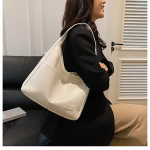 Detailed close-up of cream PU leather tote bag with lychee texture and side pocket detail