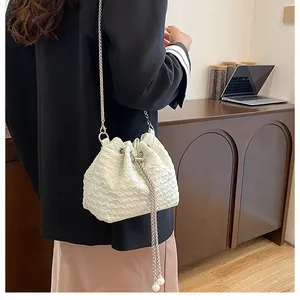 Détail du sac seau à cordon vert clair avec texture plissée et accents de perles