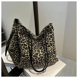 Detalle del bolso tote de lona con estampado de leopardo y correas de cuero fino