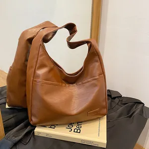 Brown vintage PU leather tote bag with front pocket shown in a lifestyle mirror reflection