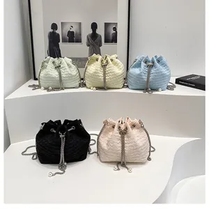 Détail macro de sacs seaux à cordon avec texture plissée et lanières en chaîne perle