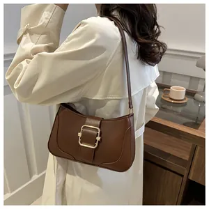 Detail view of brown PU leather underarm bag with a stylish gold square buckle on the strap