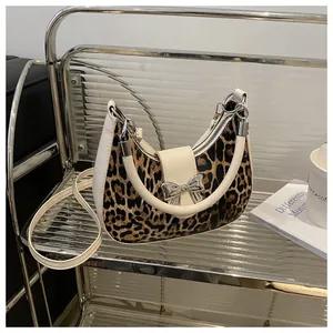 Dettaglio borsa a sella leopardata con fibbia a fiocco argento e finiture bianche