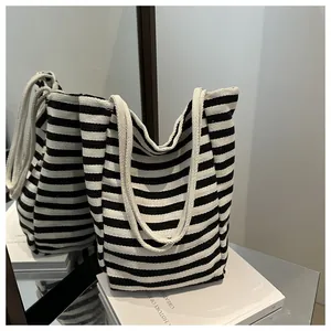 Detailed view of striped canvas tote bag with thick woven straps for daily commute