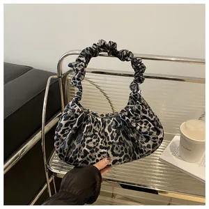 Close-up of leopard print ruched handbag with velvet texture and soft cloud shape