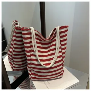 Macro detail of red and white striped tote bag showing durable woven canvas texture