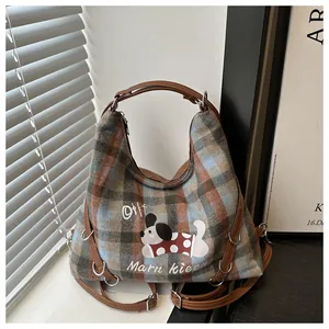 Detail of plaid tote bag featuring cartoon dog print and durable brown leather straps