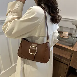 Minimalist dark brown underarm bag with gold buckle and smooth leather texture