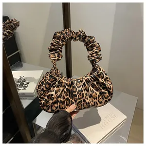 Detail of trendy leopard print handbag featuring a vintage-style ruched circular handle