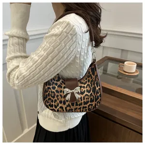 Elegante borsa hobo leopardata con fiocco argentato e tracolla marrone in scena urbana