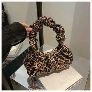 Detail of leopard print handbag featuring a ruched scrunchie handle and autumn cloud style