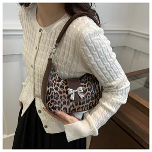 Dettaglio borsa hobo leopardata con fiocco argentato e manico in pelle di qualità