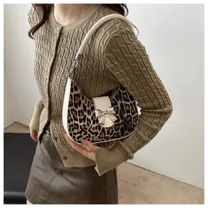 Dettaglio della borsa hobo leopardata con tracolla bianco sporco e fibbia a fiocco