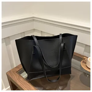 Dettaglio della pelle sintetica nera testurizzata su una grande borsa tote minimalista