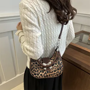 Borsa a mezzaluna con stampa leopardata e fibbia a fiocco d'argento indossata
