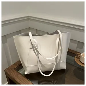 Dettaglio della borsa tote bianca in pelle con trama fine e cuciture rinforzate sulla tracolla