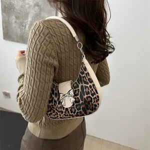 Borsa a tracolla leopardata alla moda con fibbia a fiocco d'argento indossata da modella