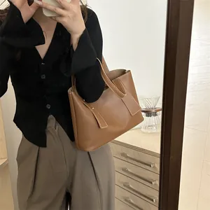 Minimalist brown leather tote bag with white contrast stitching for daily commute