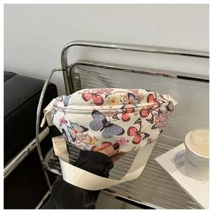 Détail d'un grand sac banane en toile blanche avec des imprimés papillons colorés