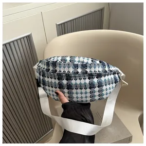 Detail van blauwe geruite tweed heuptas met brede witte nylon riem en ritssluiting