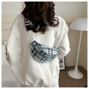 Detail van de blauw-witte geruite tweed heuptas met brede riem en gespsluiting