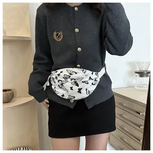 Détail d'un sac de poitrine en toile blanche avec imprimés papillons noirs et sangle réglable