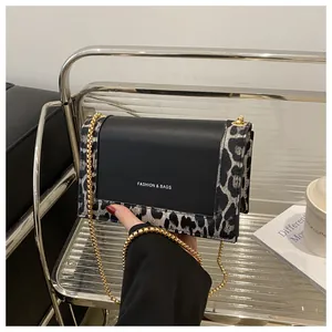 Close-up of leopard print crossbody bag with gold chain strap and fashion logo
