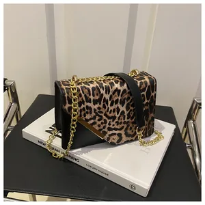 Detail of leopard print shoulder bag with gold metal chain and sleek leather strap