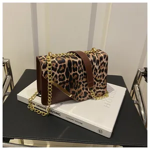 Detail of leopard print handbag with golden chain strap and leather texture
