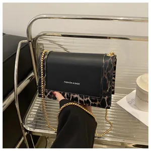 Detail view of the leopard print patchwork crossbody bag with elegant gold chain strap