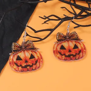 Σκουλαρίκια κολοκύθας Halloween με λεοπάρ φιόγκους σε πορτοκαλί εορταστικό φόντο