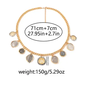 Macro view of gold curb chain necklace featuring textured geometric coin pendants