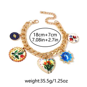 Détail d'un collier double chaîne en alliage avec pendentifs floraux en émail coloré et fermoir