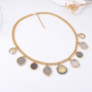 Detail of gold Cuban chain necklace with mixed metal coin pendants and lobster clasp