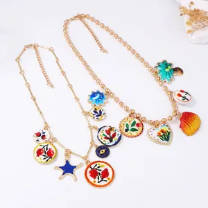Détail du collier double chaîne bohème avec pendentifs émaillés aux motifs floraux