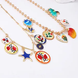Détail de collier doré avec pendentifs émaillés colorés aux motifs de fleurs