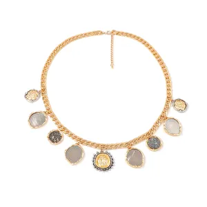 Chunky gold chain necklace featuring multiple geometric coin pendants in mixed textures