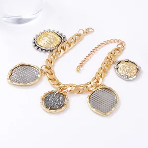 Gold chunky chain necklace with vintage geometric pendants on a minimalist white background