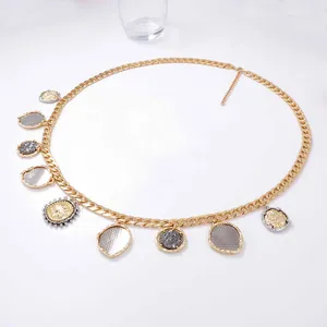 Minimalist gold metal chain belt with multi-color geometric coin pendants on white background