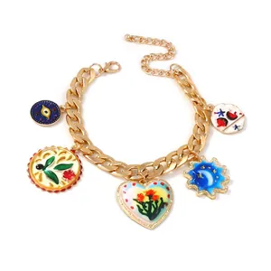Vue détaillée du bracelet en chaîne dorée avec breloques en émail et fermoir homard