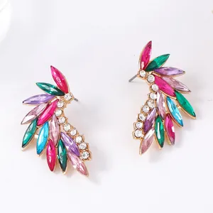 Detailed macro view of gold alloy feather earrings with colorful zircon gemstones