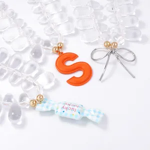Colorful pendant set with orange letter S, lucky candy charm and silver metal bow