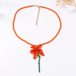 Orangefarbene Blumenkette mit grünem Stiel an oranger Kordel mit goldenem Karabiner