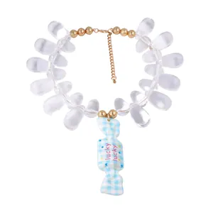 Detail of beaded necklace with blue checkered candy pendant and lucky engraving