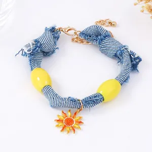 Close-up of blue denim braided bracelet with yellow resin beads and sun pendant