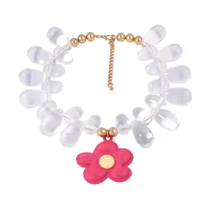 Detail of beaded necklace with transparent water-drop beads and pink flower pendant