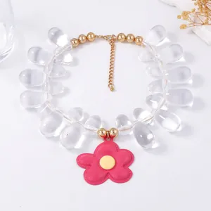 Detail of beaded necklace with transparent water drop beads and large pink flower pendant
