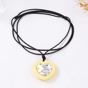 Vue détaillée d'un pendentif cœur 3D avec zircon sur un collier en cordon noir
