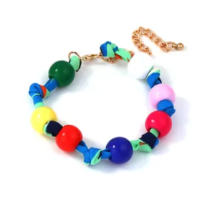 Detail of bohemian braided rope bracelet with vibrant multicolored beads and gold clasp