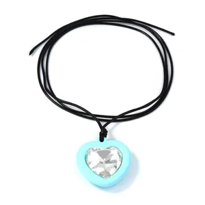 Détail d'un pendentif cœur bleu clair avec zircon facetté sur un cordon noir